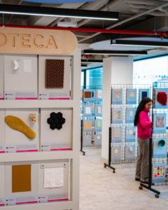 Una mujer observa diferentes muestras de materiales en un espacio de exhibición.