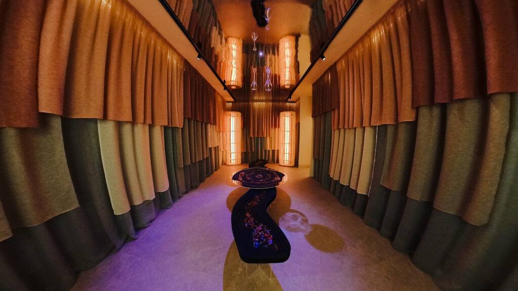 La imagen muestra una habitación moderna decorada con cortinas y luces cálidas.