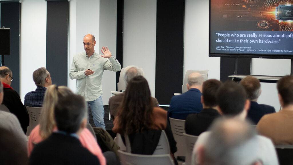 Un ponente está dando una charla ante un público en un evento sobre tecnología.