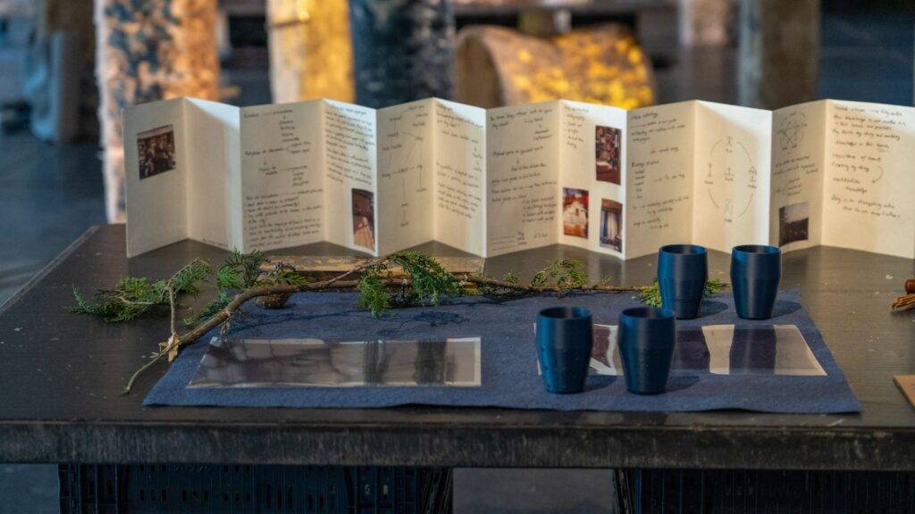 Una mesa decorada con un menú desplegable y copas azules sobre un mantel azul.