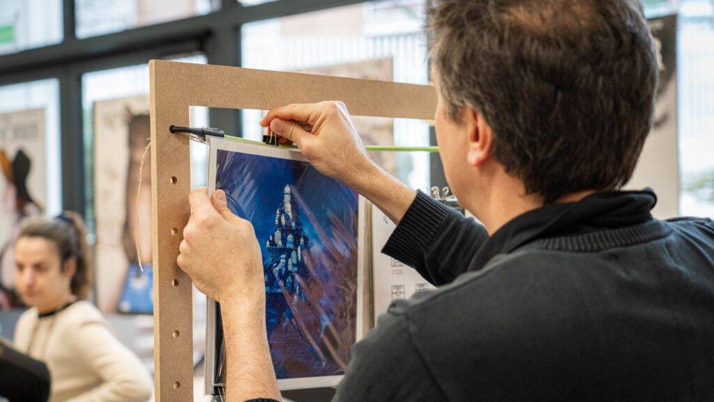 Una persona está colgando una imagen en un panel de exhibición.