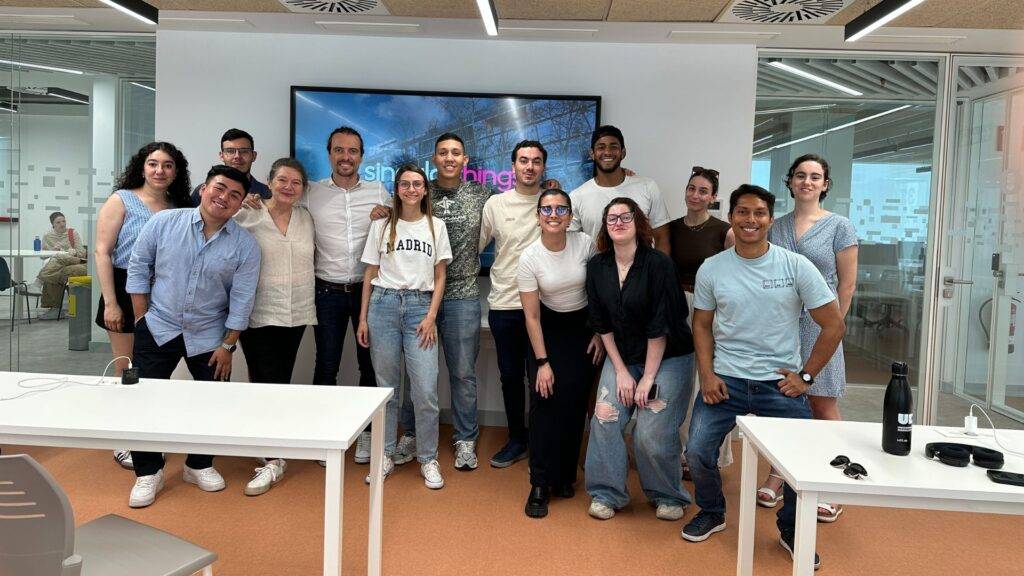 Un grupo de personas posando en una sala de oficina moderna.