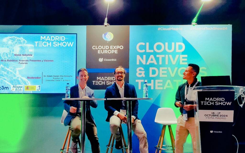 Una mesa redonda en el Madrid Tech Show con tres ponentes discutiendo sobre tecnología y futuro.