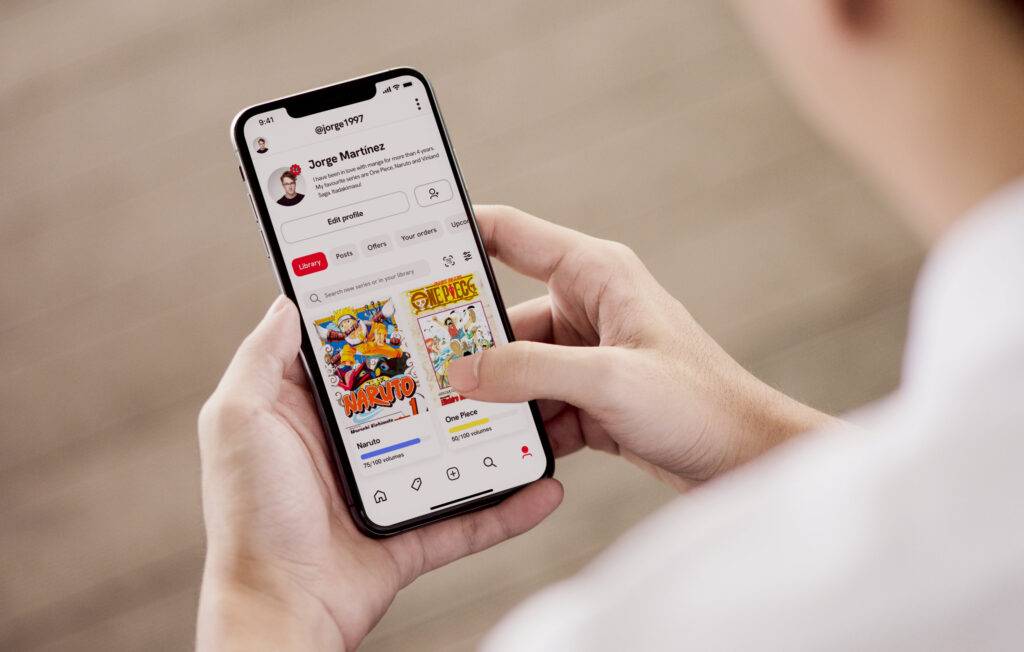 Una persona sosteniendo un teléfono móvil mientras navega por una aplicación de entretenimiento.