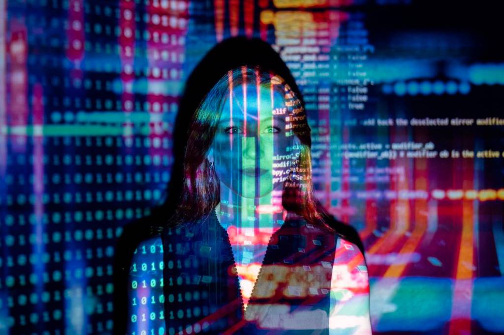 La imagen muestra a una persona con un fondo digital y códigos en colores vibrantes.