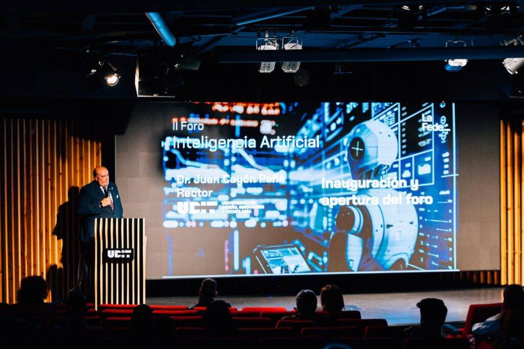 Un evento sobre inteligencia artificial con un ponente en el escenario y una presentación proyectada.