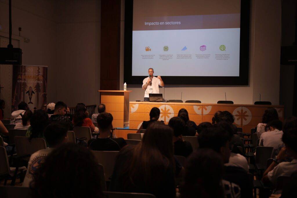 Un ponente habla ante un público en un evento sobre el impacto en distintos sectores.