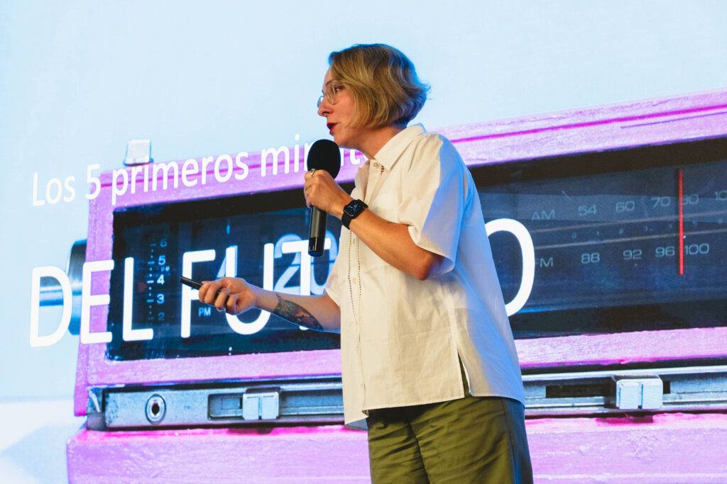 Una persona está hablando frente a una pantalla con un gráfico sobre comunicación.