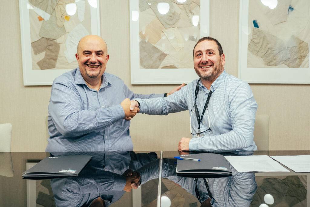 Dos hombres se dan la mano en una reunión formal.