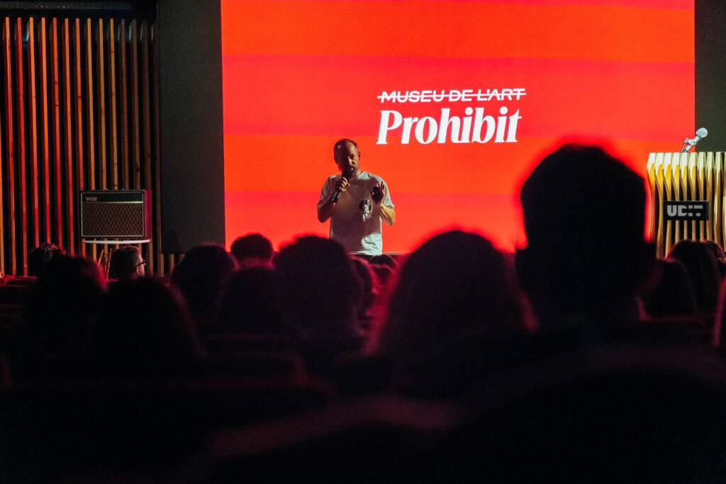 Un ponente habla frente a una audiencia en un evento en el museo de arte.