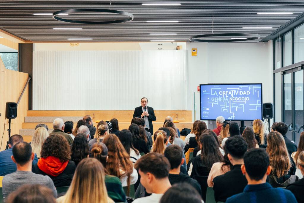Una conferencia sobre creatividad con una amplia audiencia en un ambiente moderno.