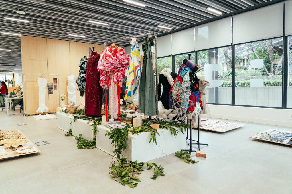 Exposición de vestidos artísticos en un espacio moderno y luminoso.