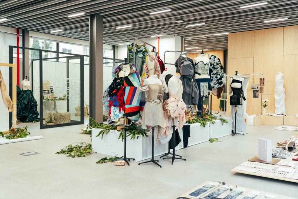 Una exhibición de moda con vestidos en maniquíes en un espacio moderno.