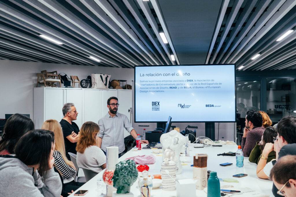 Un grupo de personas asiste a una charla sobre diseño en un ambiente moderno y colaborativo.
