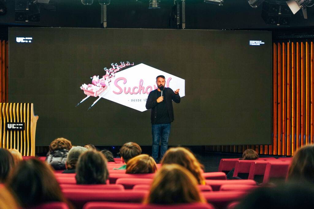 Un ponente está hablando en un evento frente a un público sentado en un auditorio.