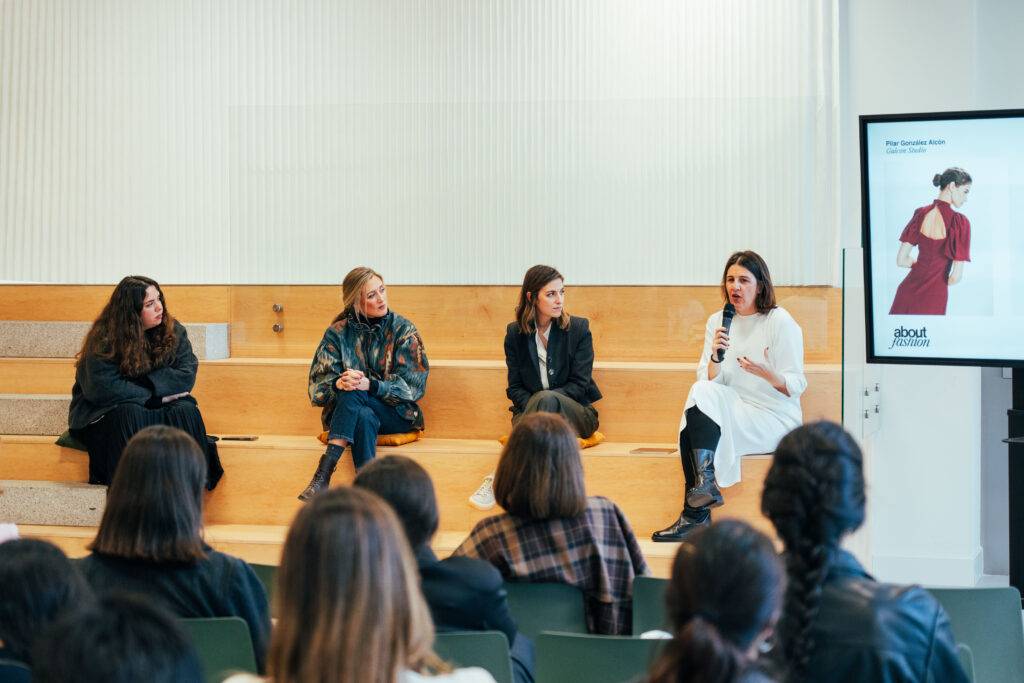 Una charla en un evento con varias ponentes sentadas en un escenario.