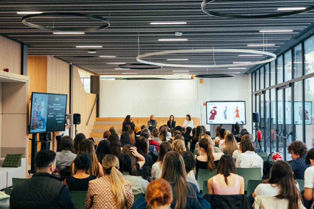 Evento académico con una audiencia participativa en un entorno moderno.