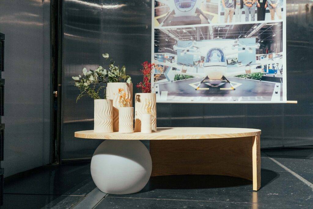 Una mesa de madera con jarrones decorativos y un fondo de exhibición.