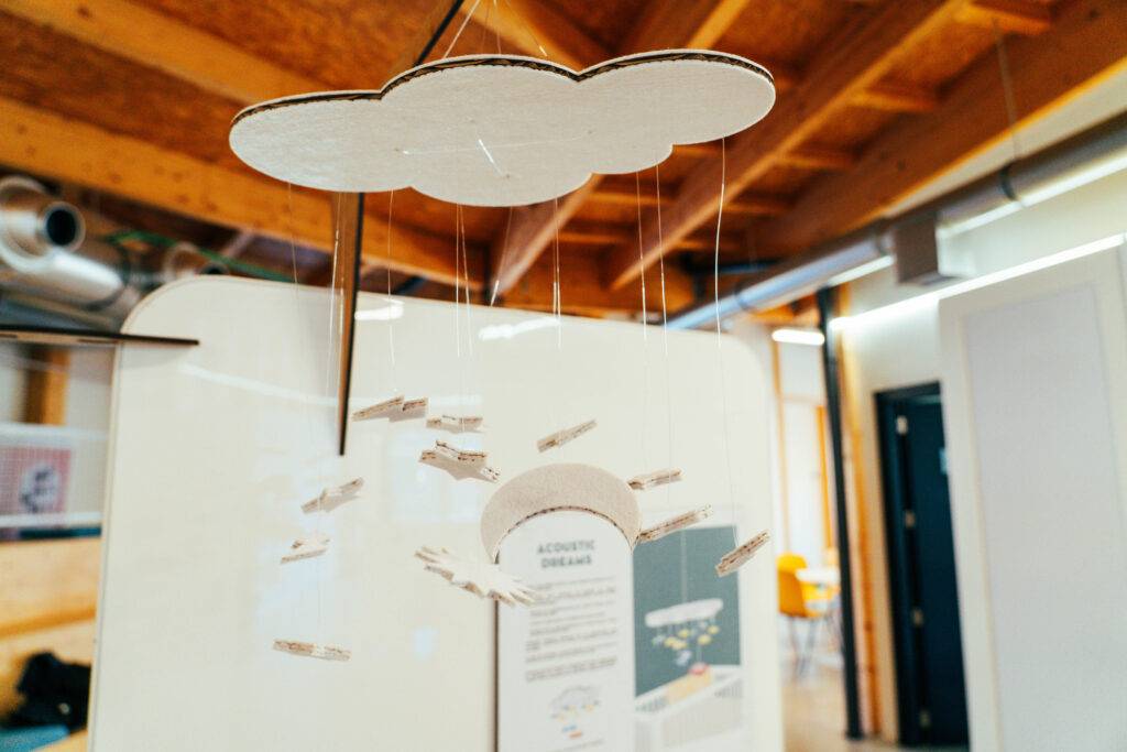 Una nube de cartón suspendida con figuras que representan lluvia en un ambiente interior.