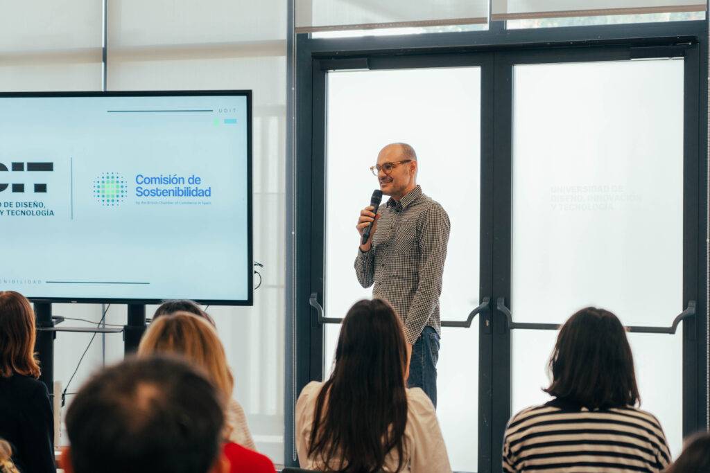 Una persona habla ante una audiencia en un evento relacionado con diseño y sostenibilidad.