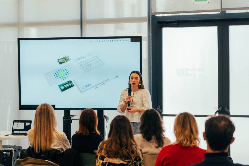 Una mujer presenta información frente a una audiencia en un evento o taller.