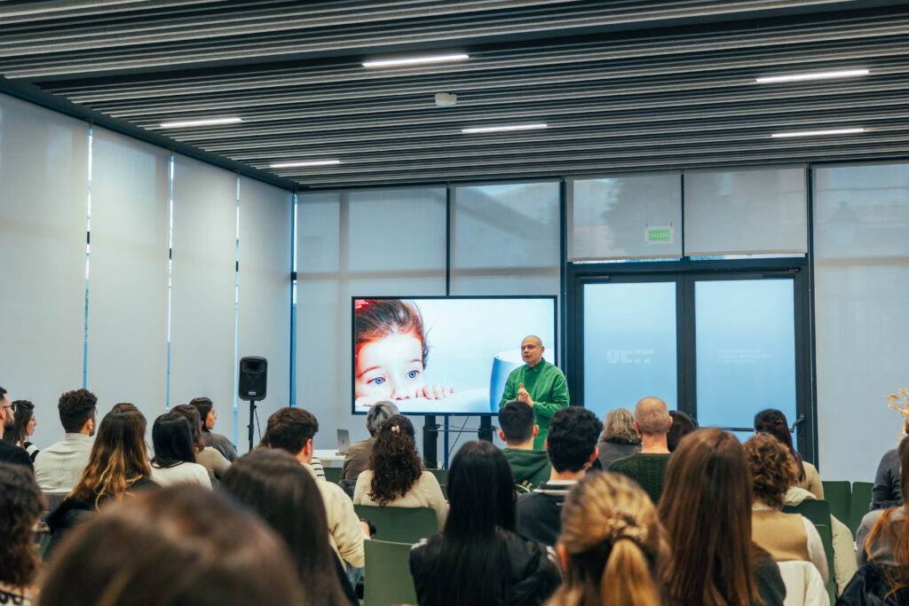 Una presentación en la que un ponente habla frente a una audiencia en una sala moderna.