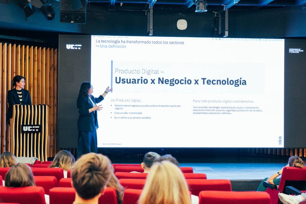 Una presentación sobre la transformación digital en un evento con ponentes y una audiencia sentada.