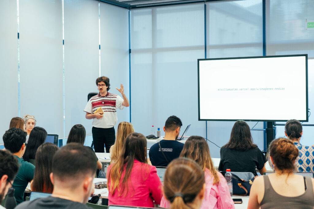 Una persona está dando una presentación frente a un grupo de personas en un aula moderna.