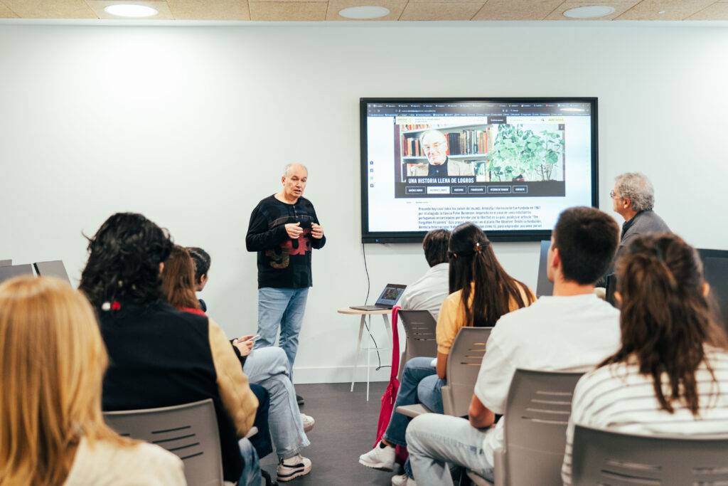 Una persona está dando una presentación frente a un grupo de personas en una sala.