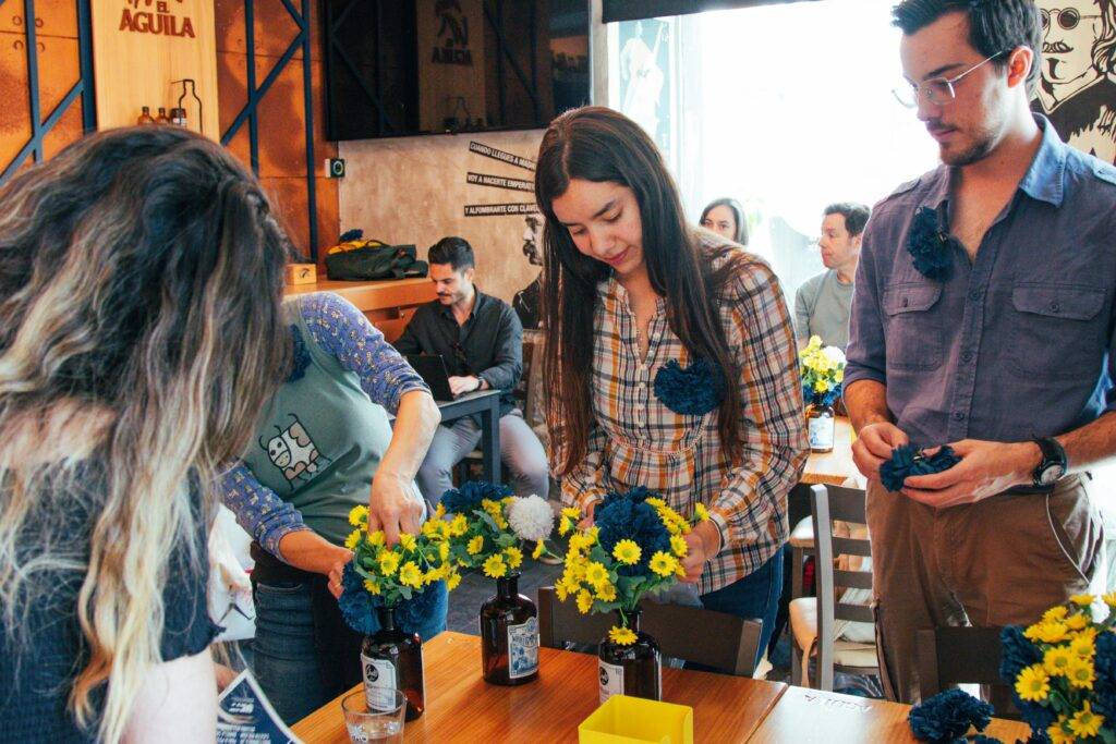 Un grupo de personas en un taller creando arreglos florales.