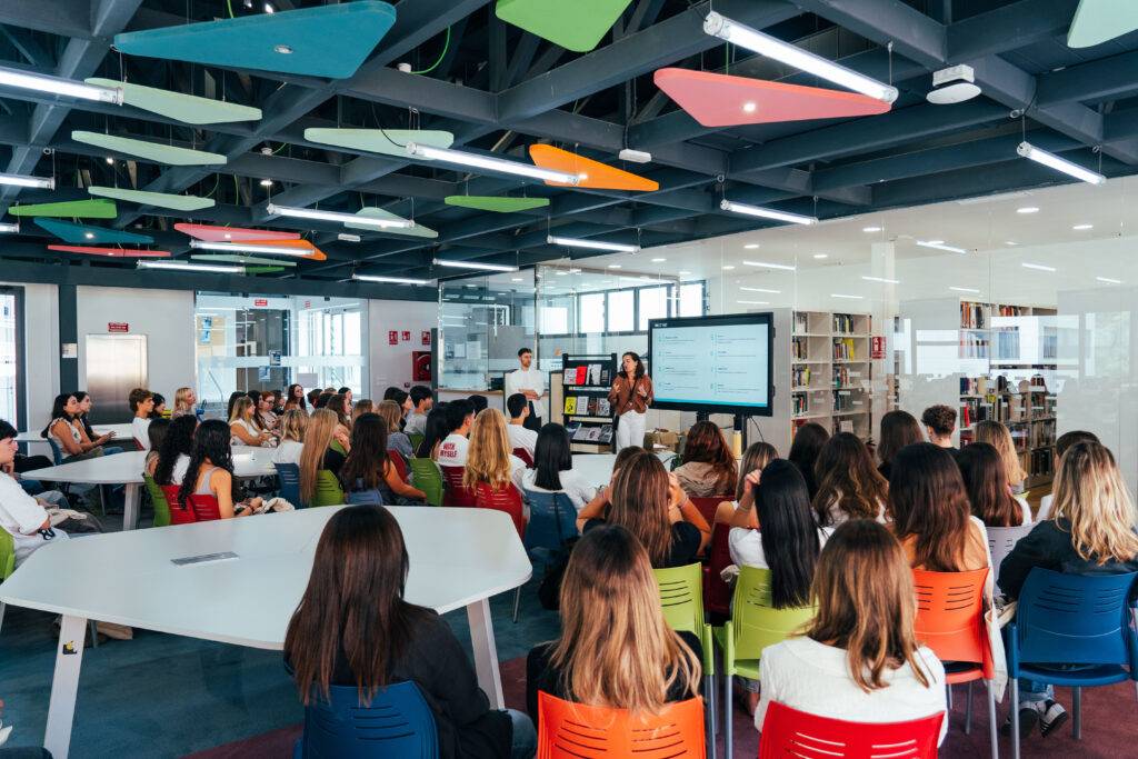 Un grupo de personas asiste a una presentación en un moderno espacio de trabajo colaborativo.