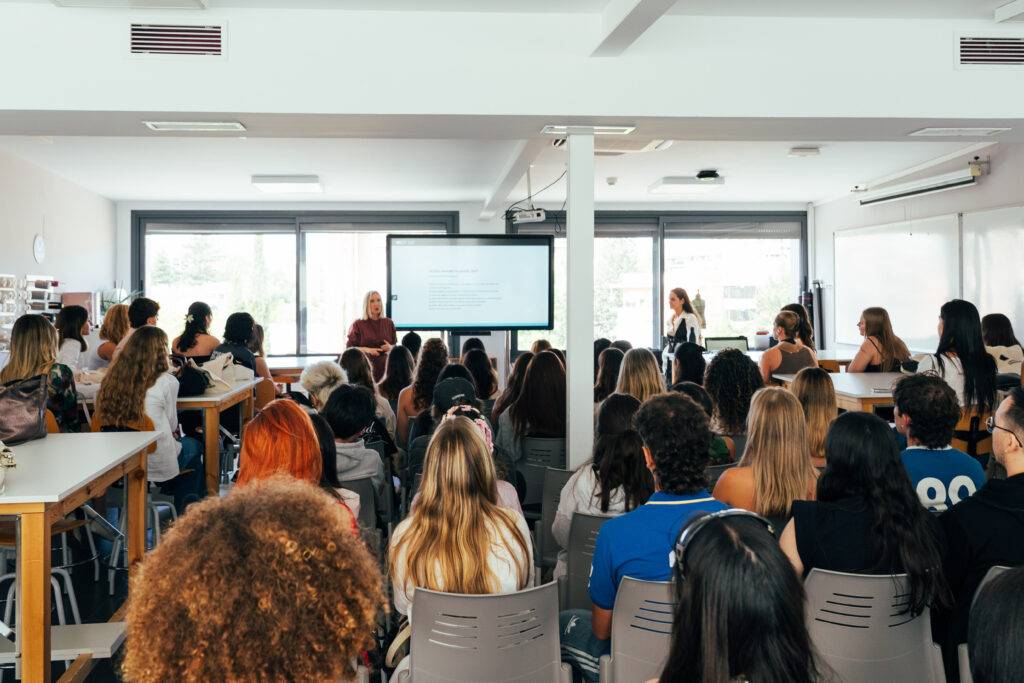 Un grupo de estudiantes está asistiendo a una conferencia en un aula moderna.