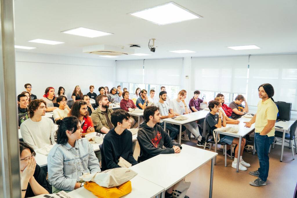 Una aula llena de estudiantes escuchando a un profesor.