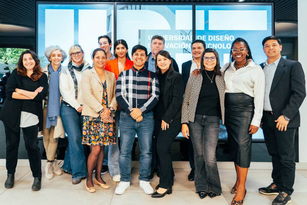 Un grupo diverso de personas posando en un entorno moderno y creativo dentro de una universidad.