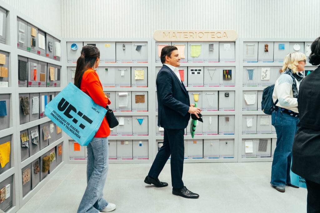 En una sala de exhibición hay varias personas observando paneles con diferentes materiales.