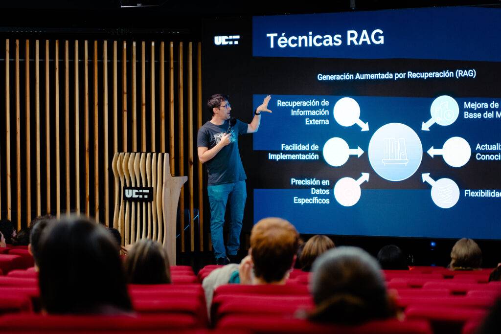 Un presentador explica las Técnicas RAG en una sala de conferencias con un proyector detrás.