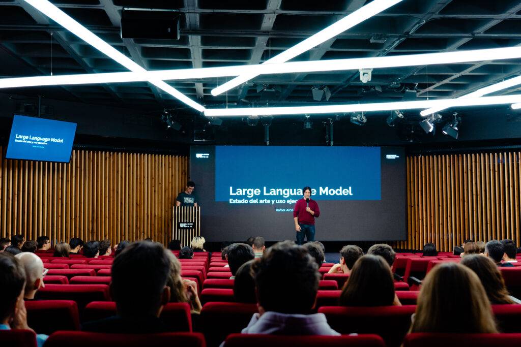 Una presentación sobre modelos de lenguaje en un auditorio lleno de gente.