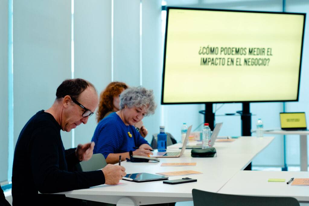 Un grupo de personas discutiendo el impacto en los negocios en una sala de reuniones.