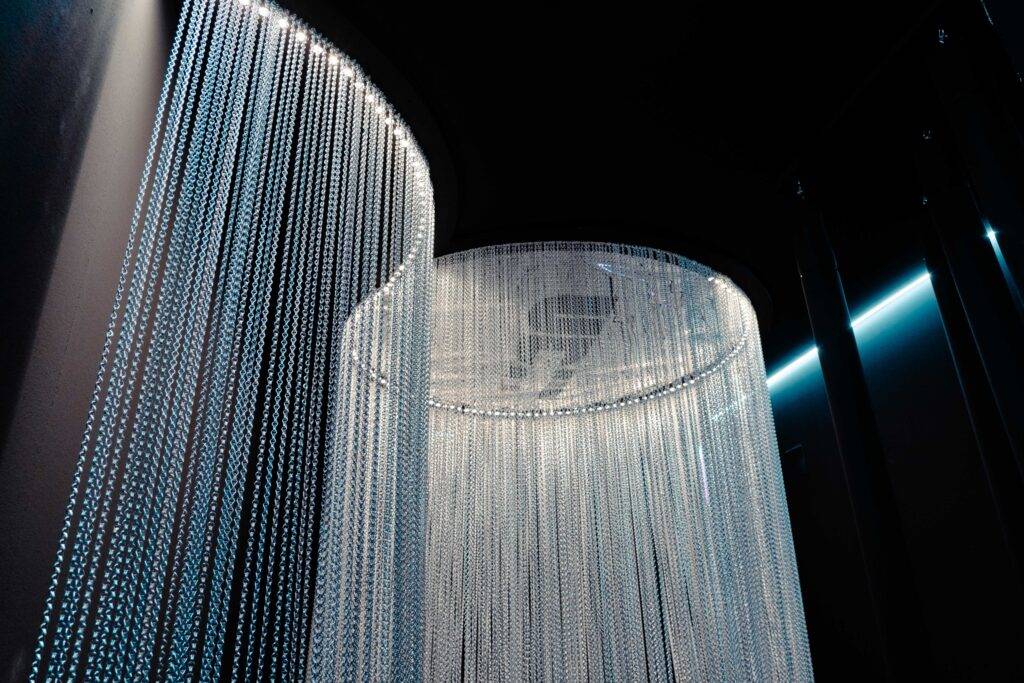 Una instalación artística con cortinas de luces que caen en cascada desde el techo.
