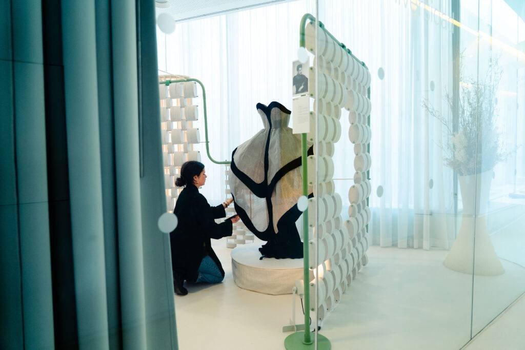 Una persona interactúa con una instalación artística en un ambiente moderno y luminoso.
