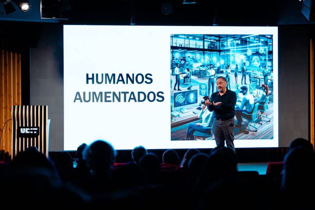 Un presentador habla sobre el concepto de humanos aumentados frente a una audiencia.