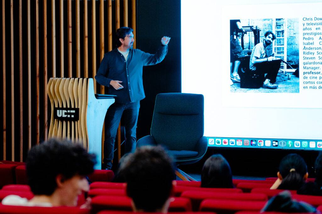 Un hombre está presentando información en una pantalla mientras un grupo de personas lo observa.