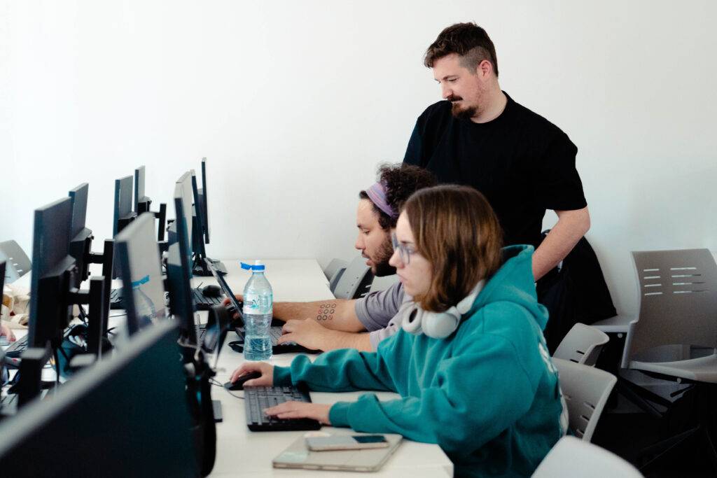 Un grupo de personas trabajando en ordenadores en un ambiente de oficina.