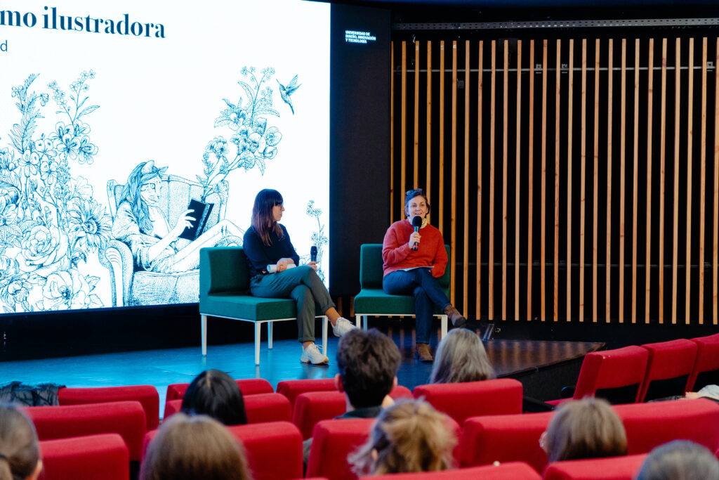 Una charla sobre ilustración en un auditorio con dos ponentes en el escenario.