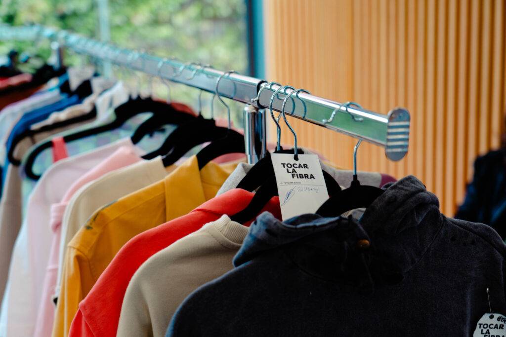 Una variedad de sudaderas colgadas en un perchero.