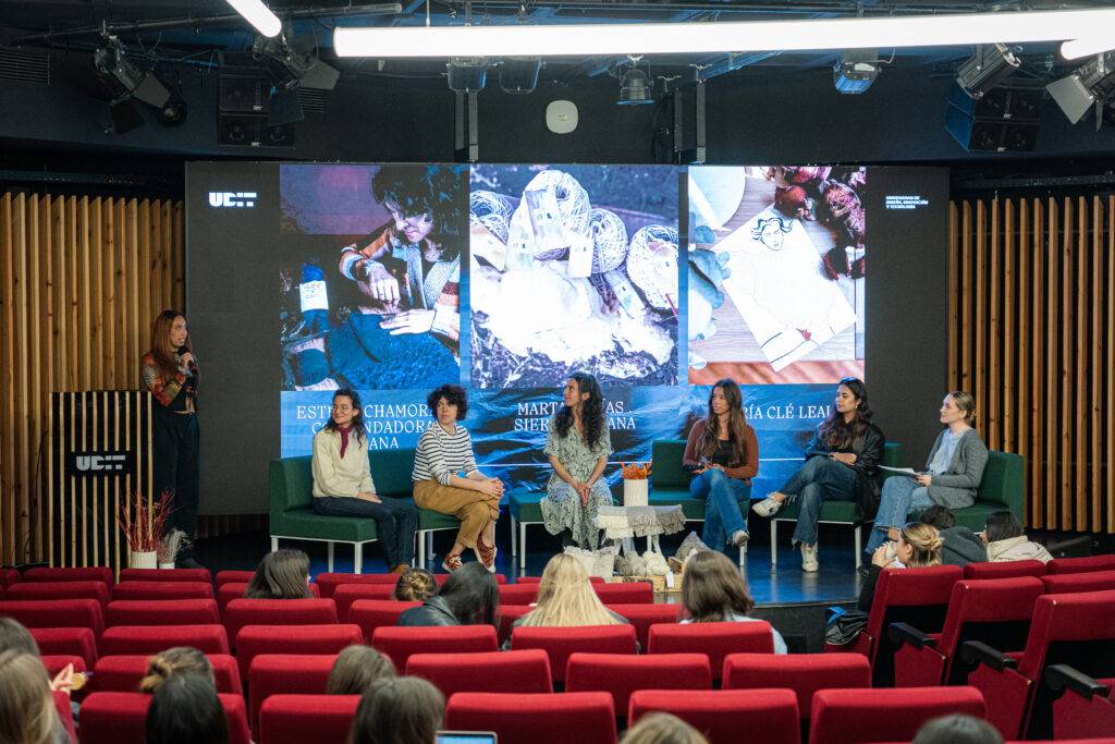 Una charla en un auditorio donde varias panelistas discuten sobre diferentes temas en un entorno académico.