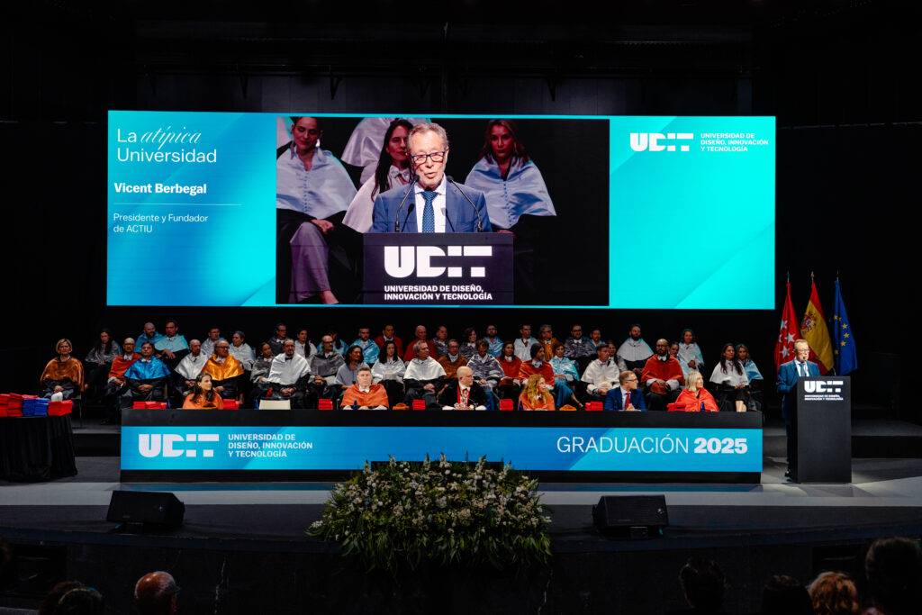 Un acto de graduación donde un hombre habla frente a un grupo de personas en un escenario.