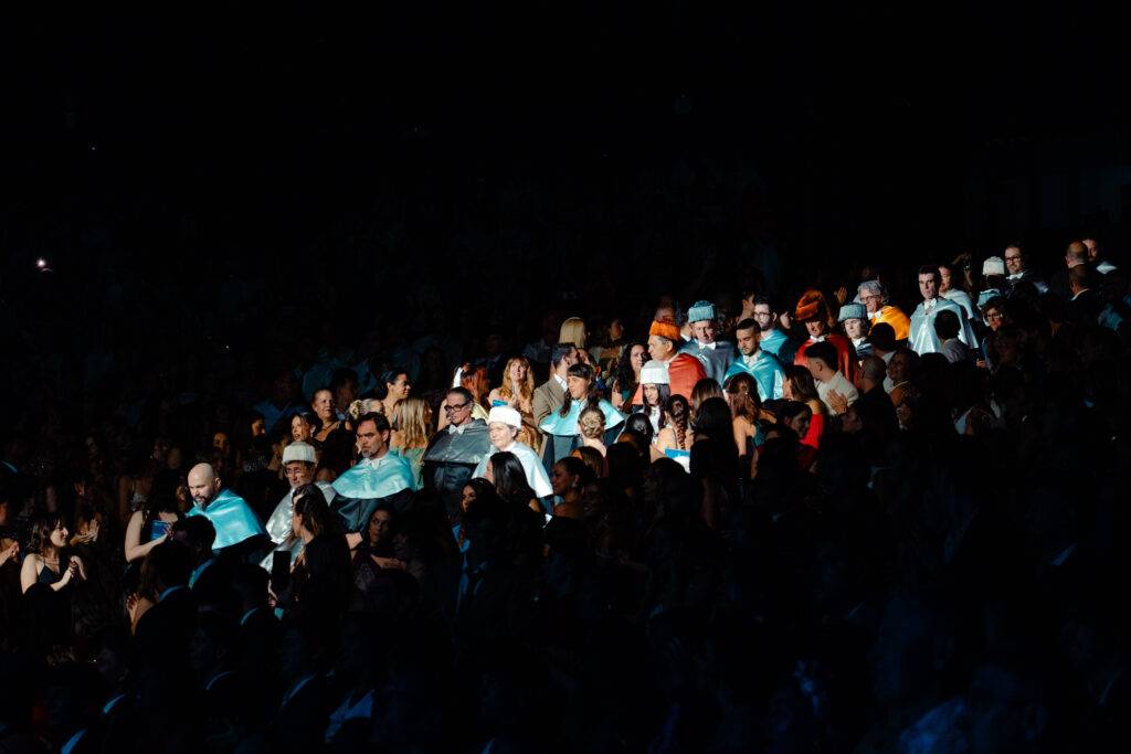 Un grupo de personas en un evento con banderas y prendas en tonos celestes y blancos.