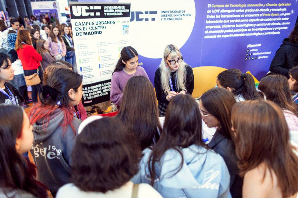 Un grupo de jóvenes se informa sobre programas educativos en un evento académico.