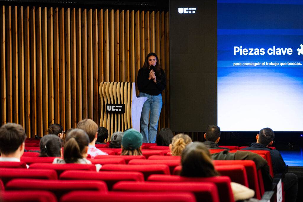 Una oradora se presenta ante una audiencia en un evento sobre consejos laborales.